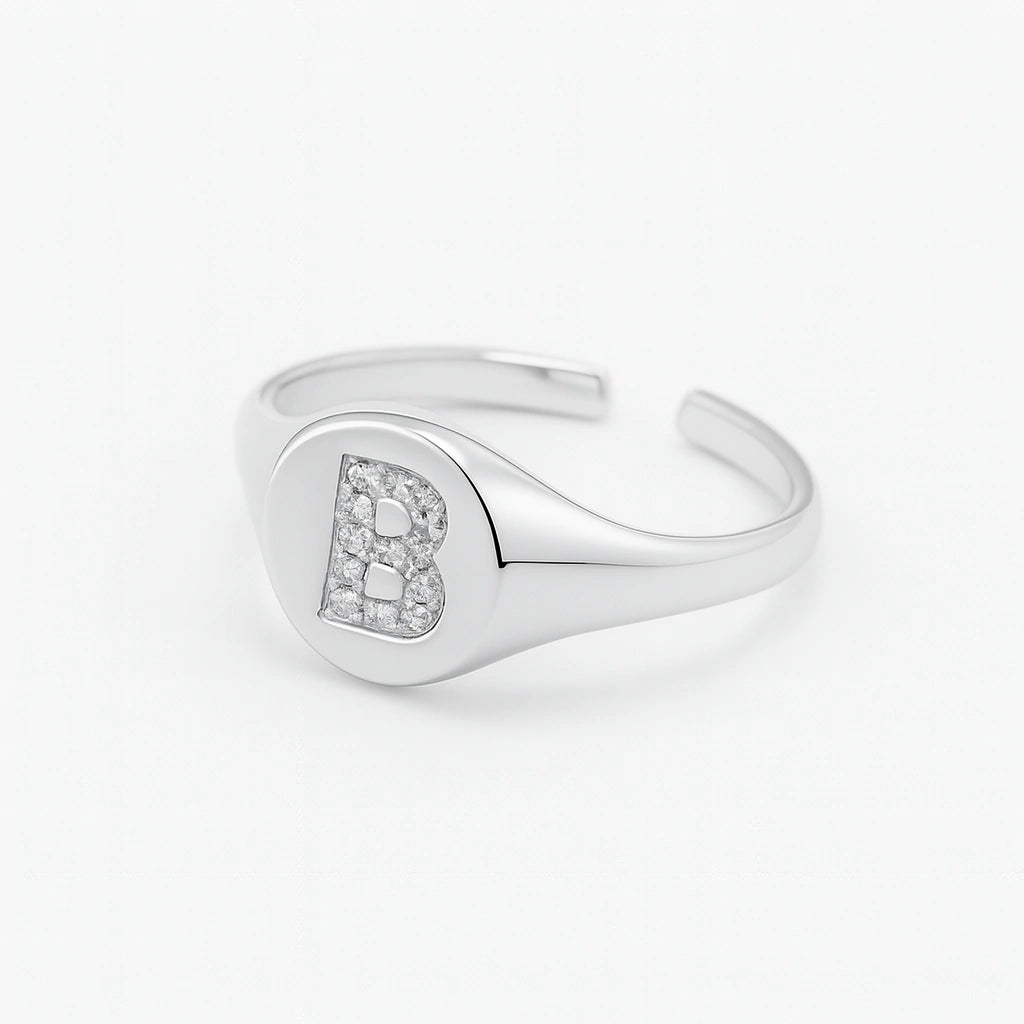 Anillo de sello de plata ajustable con letra pavimentada