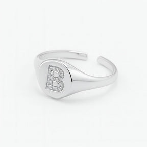 Anillo de sello de plata ajustable con letra pavimentada